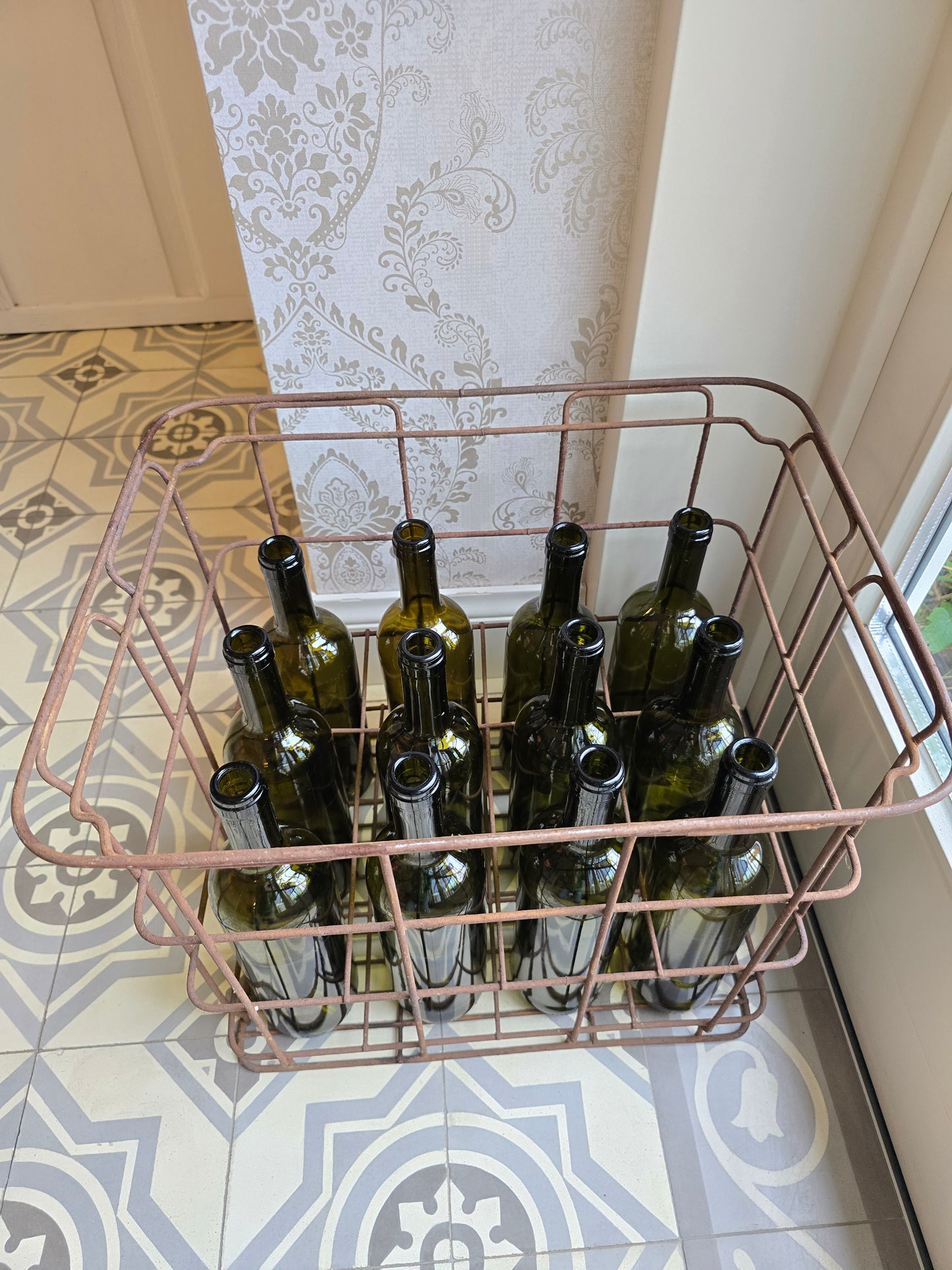 Oude metalen flessenbak met 12 vintage flessen