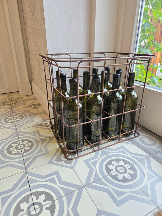 Oude metalen flessenbak met 12 vintage flessen