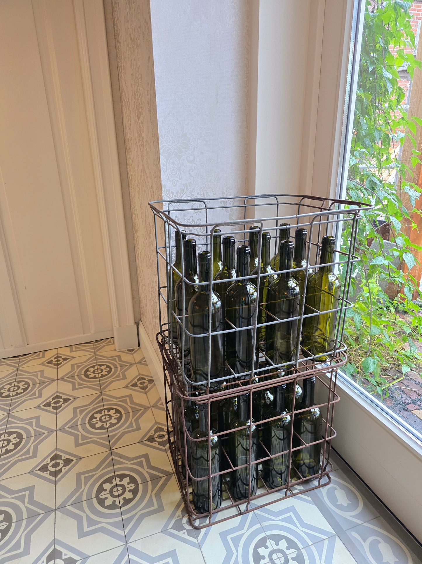 Oude metalen flessenbak met 12 vintage flessen